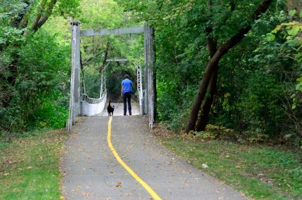 Roller Blader and dog crossing crooked bridge